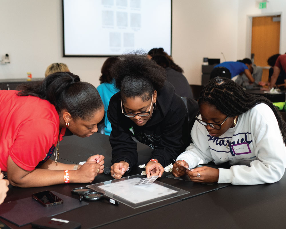 three students in a group reading instructions together