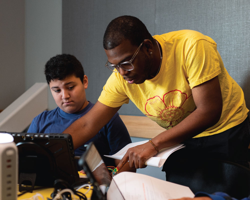 instructor helping a student on their laptop