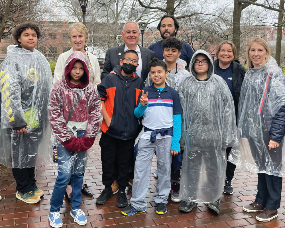 group of smiling students and adults wearing ponchos outdoors